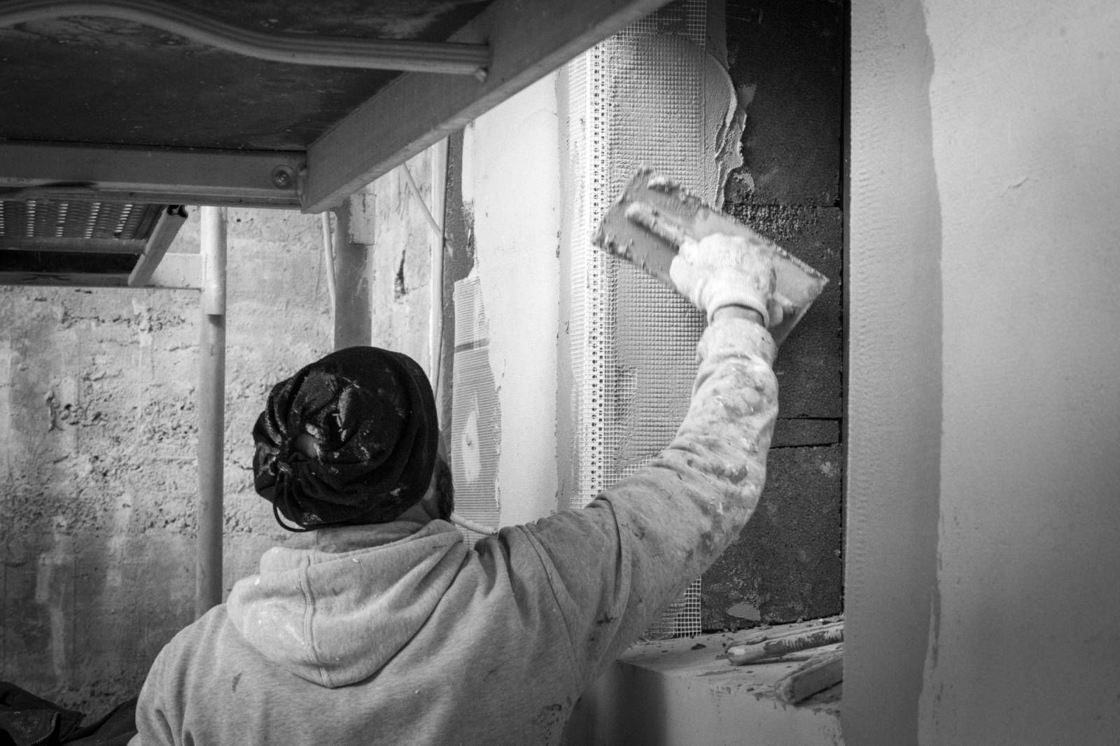 Un compagnon Delagarde au travail sur l'enduit d'une façade